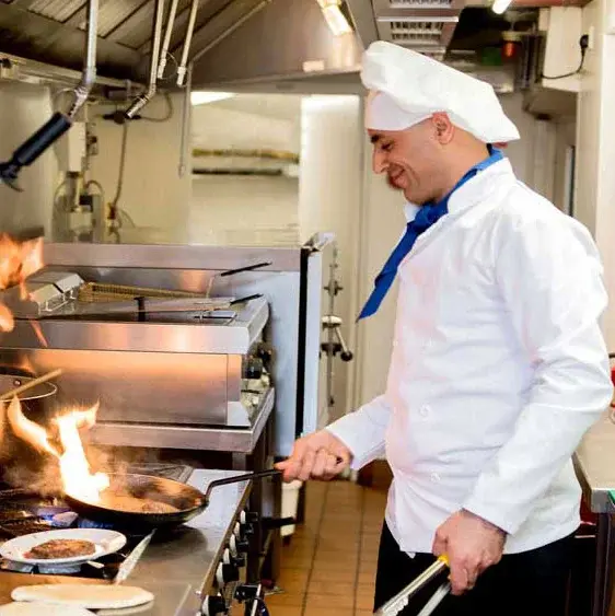 The Palms at La Quinta Chef Created Meals, chef frying a dish.